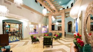 A hotel lobby with a curved ceiling, seating areas, and a reception desk. - CG 1407 Rolling Fairway Rolling Skies Poolside Cinema Spa Near Disney (Davenport)