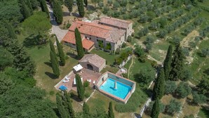 An aerial view of a property with a large building, a swimming pool, and surrounding greenery. - Podere Gabbiano, Castellina in Chianti, Siena and Chianti (Castellina in Chianti)