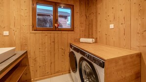 A wooden-walled laundry room with a washing machine, a sink, and a window. - Chalet Altitude - Panoramic view - 8 pers (Bernex)