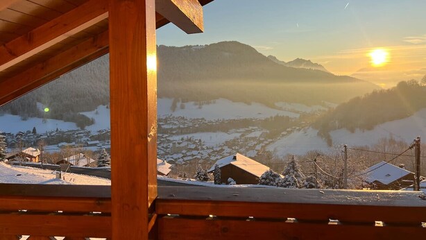 A wooden balcony with a view of a snowy landscape and mountains during sunset. - Chalet Altitude - Panoramic view - 8 pers (Bernex)