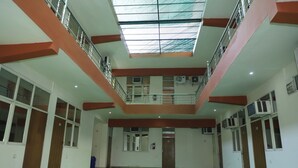 A spacious indoor area with a high ceiling, a skylight, and a green carpeted floor. - Hotel Chetali (Bijnor)