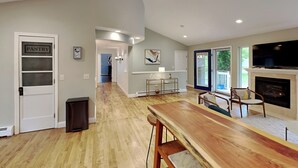 Una cocina amplia con una mesa de comedor de madera, una chimenea empotrada y un televisor grande.