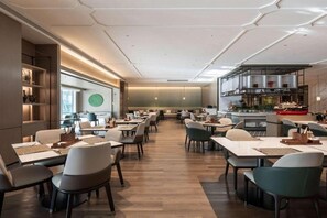 Moderni ravintola, jossa on pitkä tiski, useita pöytiä ja baarialue.