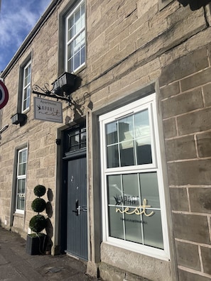 A two-story stone building with a sign reading 'ApartHotel' and 'APART nest' on the windows. - 'Mac' in Allandale ApartHotel (Auchterarder)