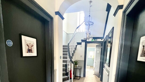 A hallway with a herringbone floor, a staircase, and a chandelier. - 'Mac' in ApartNest ApartHotel (Auchterarder)