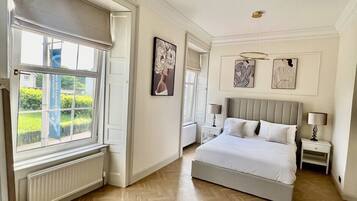 Een slaapkamer met een groot bed, een raam met uitzicht en een radiator.
