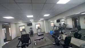 Una palestra con tapis roulant, cyclette e macchinari per l'allenamento con i pesi.
