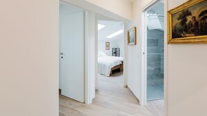 A hallway leading to a bedroom with a bed, a glass door, and a framed painting on the wall. - Amazing flat with big terrace and private car park (Verona)