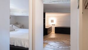 Een kamer met stapelbedden, een klein bureau en een nachtkastje.