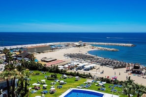 A coastal resort with a swimming pool, beach area, and marina.
