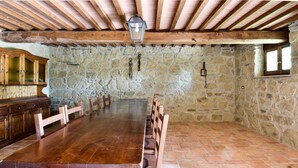 A spacious room with a long wooden table, stone walls, and a wooden ceiling. - Beautiful country house in the heart of Tuscany (Capolona)