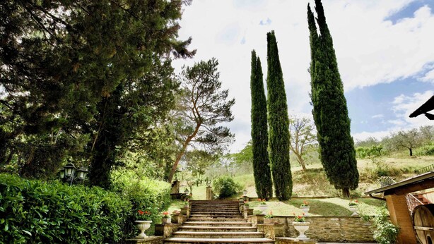 A stone staircase leading up to a building with a wooden barrel and a stone wall. - Beautiful country house in the heart of Tuscany (Capolona)