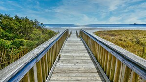 A wooden boardwalk leading to a beach with a pier in the distance. - Remodeled, Open Airy Condo, With Full Access , 1706 Brighton 3 Bedroom Condo (Myrtle Beach)
