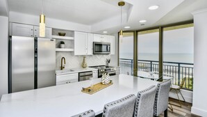 A modern kitchen with a large island, stainless steel appliances, and a view of the ocean. - Remodeled, Open Airy Condo, With Full Access , 1706 Brighton 3 Bedroom Condo (Myrtle Beach)