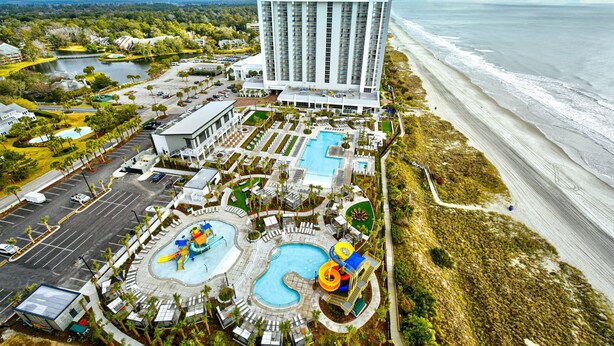 A resort with a large pool area, a beach, and a tall hotel building. - Remodeled, Open Airy Condo, With Full Access , 1706 Brighton 3 Bedroom Condo (Myrtle Beach)