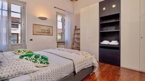 Ein Schlafzimmer mit Bett, Kleiderschrank und Fenster.
