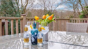 Lasipöydällä on Fever-Tree-mineraalivesipulloja ja Harahoga-giniä, maljakossa tulppaaneja ja siinä on myös punottu tuoli.