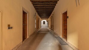 A long corridor with wooden doors on either side, leading to a central open space. - Palazzo Cavalli - Deco' (Verona)