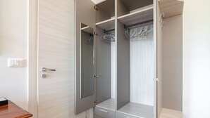 Un vestidor amplio con espejo, espacio para colgar ropa y cajones.