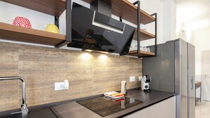 Una cocina moderna con horno empotrado, refrigerador de acero inoxidable y un salpicadero de madera.