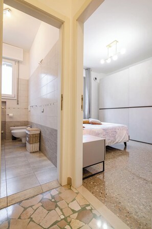 Une salle de bain moderne avec des toilettes, un bidet et un petit panier en osier.
