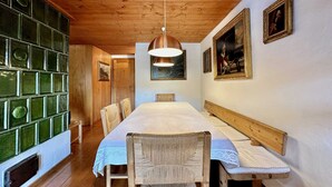 A wooden-paneled room with a long table, chairs, and a hanging light fixture. - Classy 3 bedroom few steps from centre (Cortina d'Ampezzo)