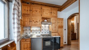 A kitchen with wooden cabinets, a stainless steel sink, a gas stove, and a built-in oven.