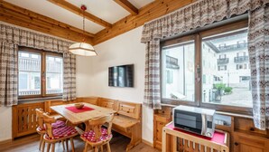 A cozy room with wooden furniture, a dining table, and a microwave.