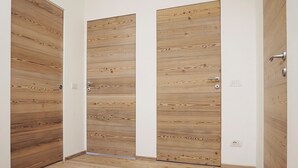 Un pasillo con puertas y suelo de madera.