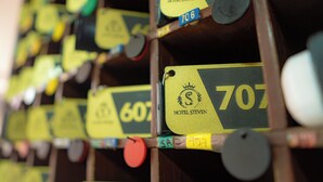 A szállodai szobaszámok egy falra vannak kiírva, táblák jelzik, hogy melyik szoba szabad, köztük a 706-os és a 707-es szoba is.
