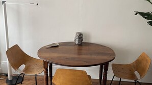 A dining area with a round wooden table, two wooden chairs, and a floor lamp. - Apartment in lively neighborhood near Marais.  (Paris)