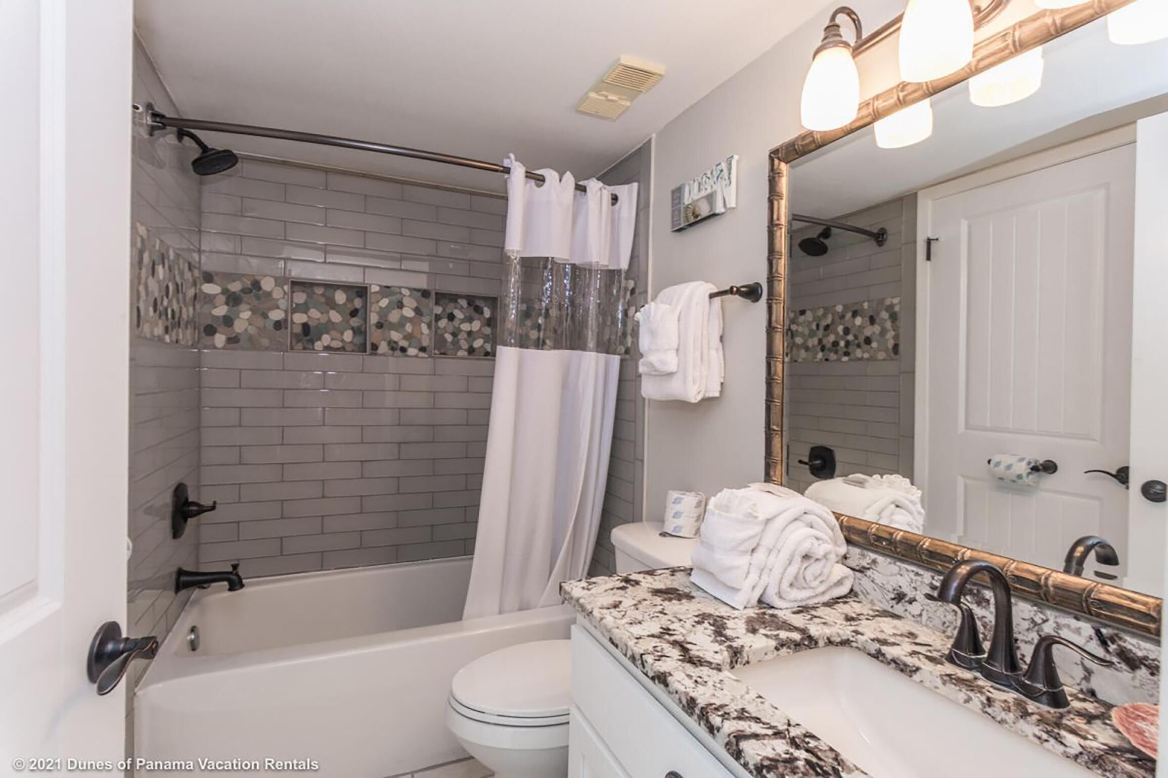 A bathroom with a bathtub, toilet, and sink.