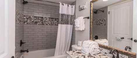 A bathroom with a bathtub, toilet, and sink.