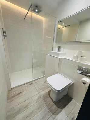 Chuveiro, toalhas de banho, sabonete, shampoo