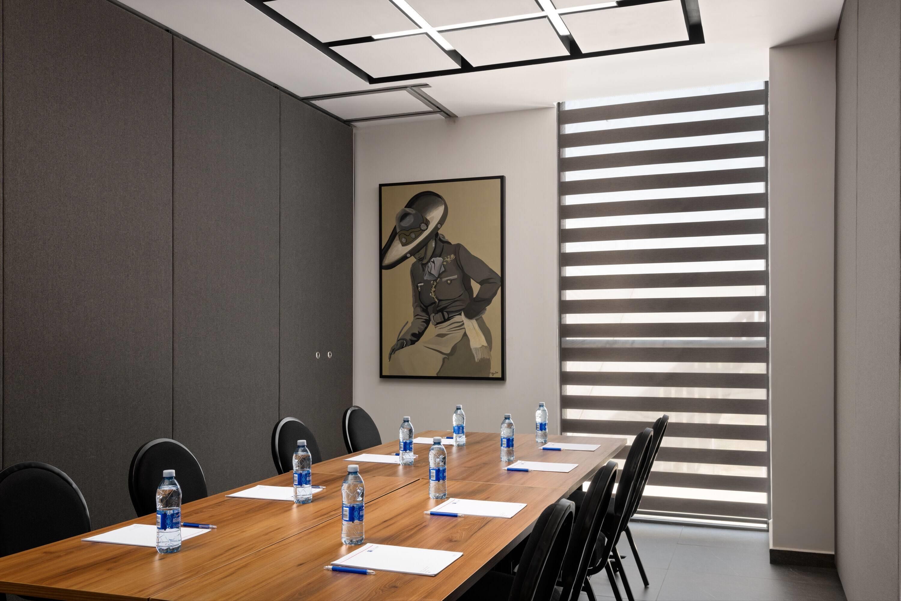 A conference room with a long table, water bottles, and papers.