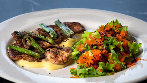 En tallerken mad med grillet kød, grønspærd og salat.