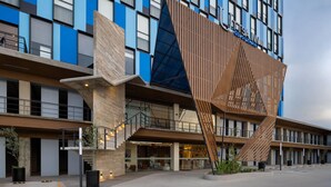 Un hôtel moderne doté d’une façade en bois remarquable et de nombreux balcons.