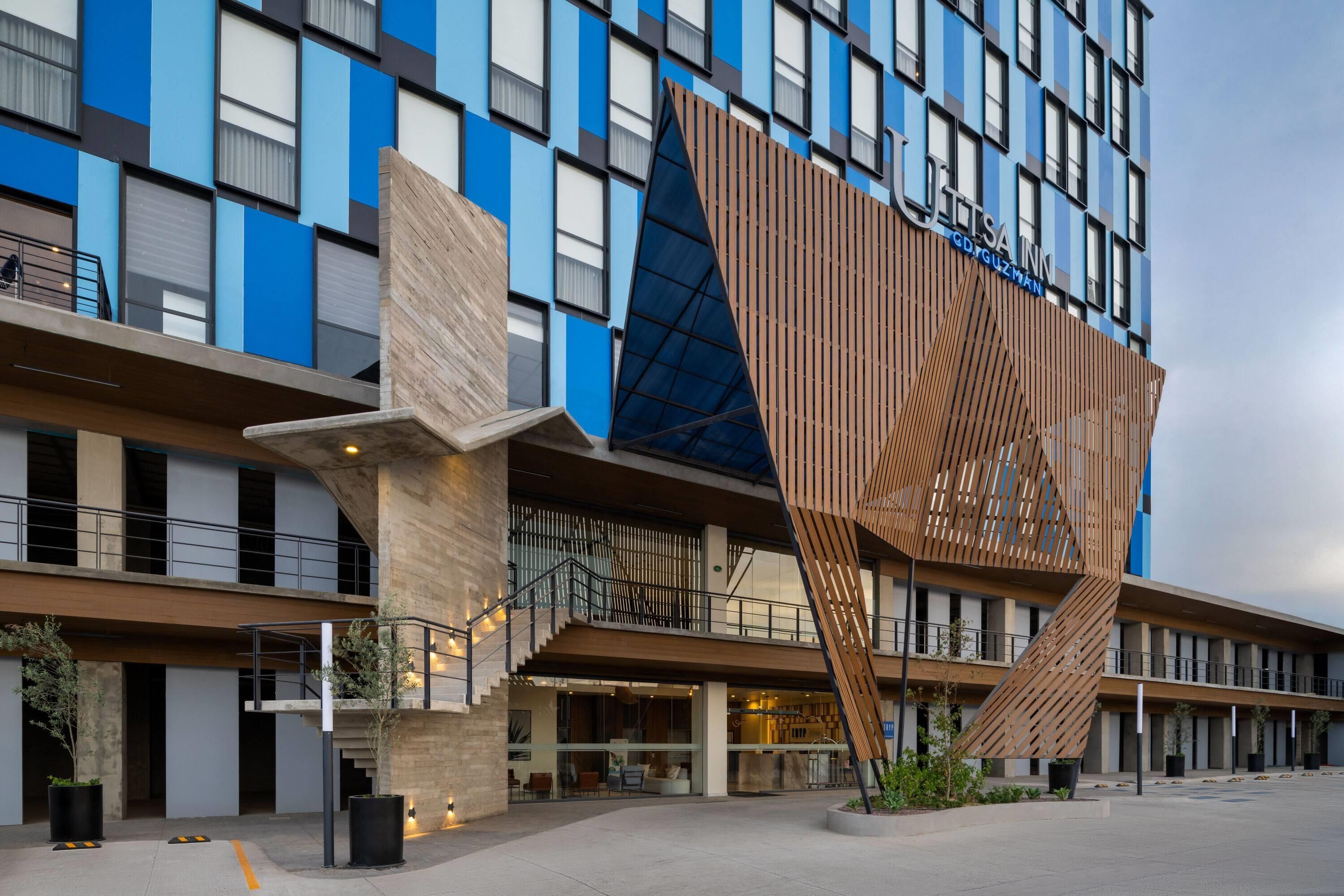 Un hotel moderno con una fachada de madera distintiva y varios balcones.