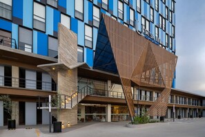 Un hotel moderno con una fachada de madera distintiva y varios balcones.