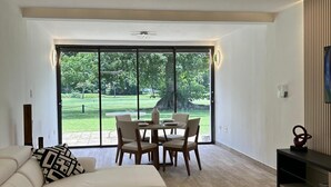A modern living room with a large sliding glass door leading to a garden. - Peaceful Apartment in Palmas del Mar (Palmas del Mar)