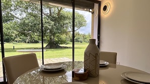 A dining area with a glass table, chairs, and a vase. - Peaceful Apartment in Palmas del Mar (Palmas del Mar)