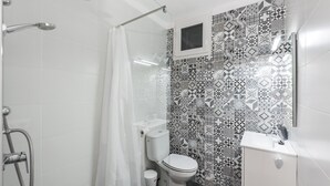 Un baño con ducha, inodoro y lavamanos.