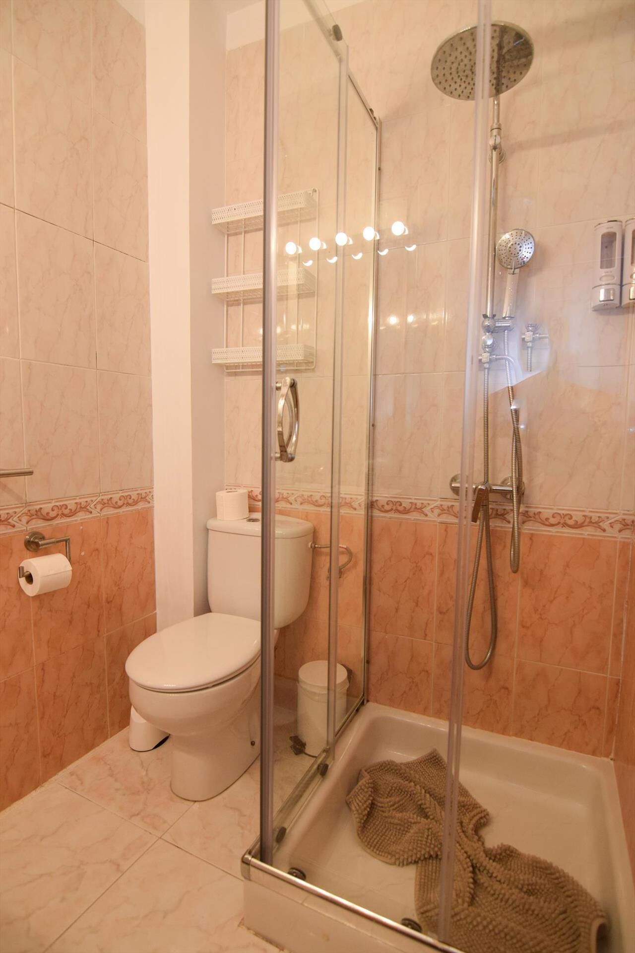 A bathroom with a glass-enclosed shower, a toilet, and a bathtub.