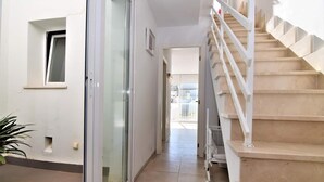 A hallway with a glass door, a staircase, and a view of the outside. - CA NA MARONA - Dúplex al centre del poble (Colonia de Sant Pere)