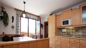 Una cocina con armarios de madera, un microondas y un lavabo.