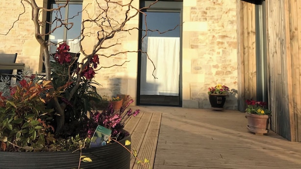 A courtyard with a stone building, a wooden door, and potted plants. - to get together with family or friends and discover Normandy (Feuguerolles-Bully)