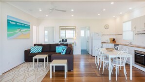 A modern apartment with a living room, dining area, and kitchen.