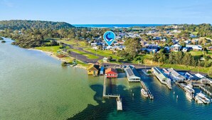 An aerial view of a coastal town with a marina, houses, and a large body of water.