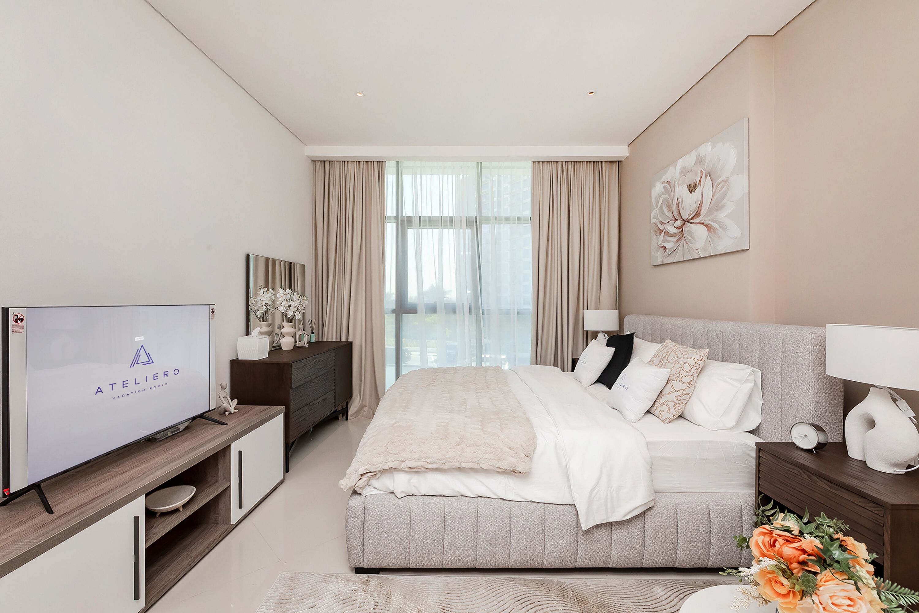Un dormitorio moderno con una cama grande, televisión y vistas al exterior.