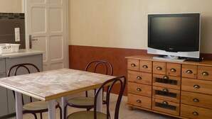 Una pequeña kitchenette con salpicadero de azulejos, una puerta blanca y un mueble de madera con cajones.